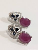 Front view of the silver earrings showing the ruby and sapphire arrangement.