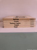 Five stacked art books on Van Gogh, Cezanne, Toulouse-Lautrec, Gauguin, Degas, all published by Doubleday.