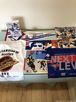 Overview photo of baseball and hockey memorabilia including Campbell Conference 1992 Playoff towel, signed baseball, Blue Jays World Series 1992 program and cards, and Blue Jays poster.