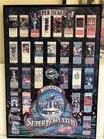 Front view of framed collection of Super Bowl tickets through Super Bowl XXVIII showing all tickets and central decorative elements.
