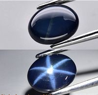 Blue star sapphire gemstone showing a high-quality six-rayed star effect under light, oval cabochon shape.