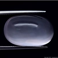 Oval cabochon cut light pink rose quartz gemstone held with tweezers, showing smooth polished domed surface and translucency under lighting.