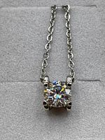 Close-up image of the pendant showing the 1 carat moissanite gemstone set in 925 silver with medium oval chain links.