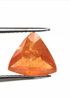 Natural unheated Fanta orange Spessartine garnet gemstone held in tweezers, showing its trillion cut shape and internal inclusions.