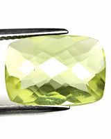 Close-up photo of the 5.17 Ct lemon quartz gemstone held by tweezers showing checkerboard cut facets and light yellow color.