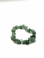 Full view of green aventurine tumbled chip stone bracelet forming a loose circle on a white background.