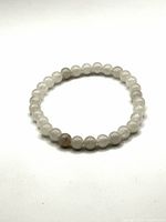 Close-up of the full circular moonstone bead bracelet showing bead color and surface finish.