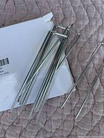 Close-up of the new metal garden stakes showing their U-shaped top and slender design.