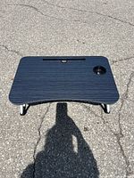 Front view of new gray laptop table top with device slot and cup holder
