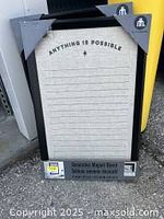 Photo of rectangular magnetic board with black frame and 'ANYTHING IS POSSIBLE' text at top.