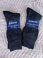 Two packs of black men's dress socks with Arrow brand labels, each pack contains 3 pairs