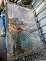 Photo of the large poster frame displaying an image of a mountain landscape, wrapped in clear protective plastic.