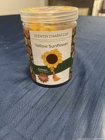 Clear plastic container labeled 'Scentsy Charm Clip Yellow Sunflower' with sunflower design and scent details