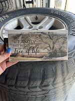 Front view showing wooden rectangular wall sign with tree image and 'Family... The roots of the tree of life' wording in dark text.