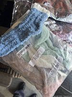 Close-up showing one blue sock alongside a sealed package containing assorted colored socks.