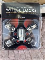 Front view of Toyota Genuine Accessories Wheel Locks package showing 4 locking lug nuts and 1 key lock adapter in sealed packaging.