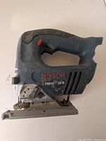 Side view showing blue plastic body, red trigger, Bosch branding, model number 52316, and metal base plate with signs of wear