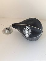 Photo of the black teardrop shaped punching speed bag with TKO logo and metal swivel mount on a light background.