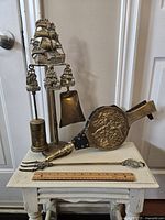Full view of antique brass fireplace tools and bellows arranged on a small table