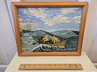Full view of framed oil painting depicting two men in a rowboat on a wavy sea with a sailboat in the background, signed Hal Black 51.