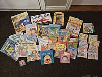 Overview of all children's board books and one small cube toy included in lot.