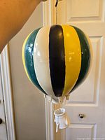 Front view showing balloon's stripes in green, white, black, yellow and hanging basket detail