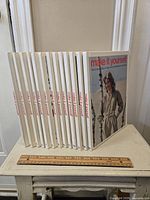 Photo showing full set of 14 hardcover "Make It Yourself" books including volume 2 and volumes 3 to 15 except volume 4, arranged on a small table with ruler for scale.