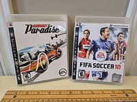 Two PS3 game cases side by side of Burnout Paradise and FIFA Soccer 10.