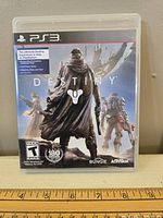 Front cover of Destiny game for PlayStation 3 with ruler below for size reference.