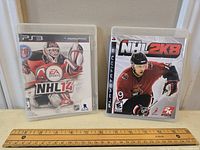 Both PS3 games NHL14 and NHL 2K8 in cases, front cover visible.