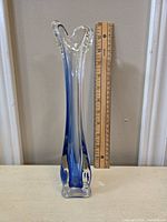 Front view of vintage swung glass bud vase with ombre cobalt blue coloring, shown with ruler for measurement.