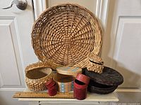 Full view of wicker plate and assorted baskets and boxes placed together.