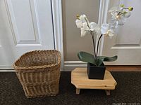 View of wooden step stool, faux orchid, and wicker wastebasket showing size and materials