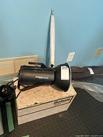 Full setup including Courtenay Solaflash 1000S studio flash head mounted with bracket, small white photo umbrella pointed upwards, original beige Courtenay box as base, and power cord.