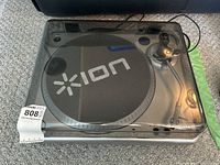 Top view of ION TTUSB10 USB turntable with clear dust cover and tonearm visible.