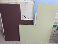 Two colored mattes in burgundy and cream, showing partial contents of boxes