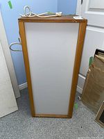 Front view of the rectangular light box showing wooden frame and translucent panel surface.