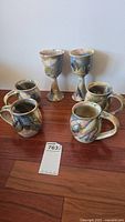 Overview of the lot showing four mugs and two wine goblets with multicolor glaze by Bailey Brown