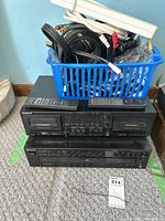 Front view of stereo cassette deck TC-WR665S stacked on top of Sony CD player CDP-C335 with blue basket of cords on top.