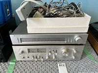 Photo showing Kenwood KT-60 AM/FM stereo tuner stacked on top of Akai AM-2600 stereo amplifier with visible front panels and controls.