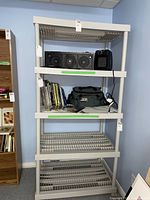 Full view of the white plastic utility shelf with various items on shelves, showing overall size and design.