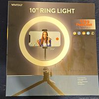 Front view of box showing Vivitar 10" ring light with phone cradle and tripod, branded as Vlog Podcast Essentials.