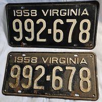 Front view of two 1958 Virginia metal license plates with embossed white numbers 992-678 on black background, showing paint wear and rust.