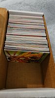Top view of many trading cards stacked in a box, showing thickness and quantity