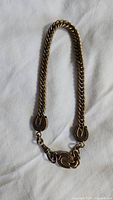 Full view of the antique pocket watch chain laid out showing twisted link design and oval end decorations.