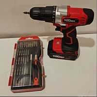 Full view of the Hyper Tough 20V cordless drill with battery installed and plastic case containing drill and driver bits arranged inside.