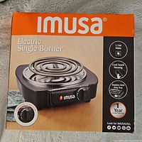 Photo of the product box showing Imusa electric single burner with product features, brand, and wattage