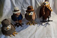 Four plush bird figures from Target Featherly Friends, each with unique hats, clothing, and scarf, posed standing on felt feet.