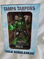 Front of box showing the Hulk bobblehead figure inside with Tampa Tarpons branding