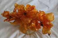 Overall view of lamp showing orange acrylic Lucite flowers and leaves with clear base.